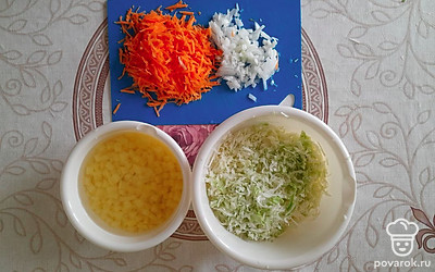 Нашинкуйте капусту, морковь натрите на крупной терке, а картофель и лук нарежьте кубиком.