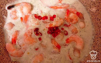 Затем добавьте в сковороду муку, тщательно размешайте и влейте вскипевшее молоко. Постоянно перемешивайте соус, чтобы не образовывались комочки. Затем добавьте креветки и готовьте еще 1 минуту.