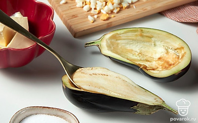 Подготовьте баклажаны. Баклажан разрежьте вдоль пополам. Аккуратно прорежьте мякоть по бокам. Возьмите ложку и уберите мякоть. Должны остаться стенки толщиной 3-4 мм. Немного посолите овощ.