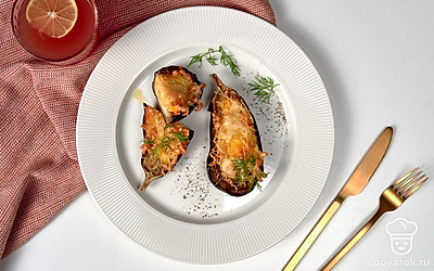 Фаршированные баклажаны будут красиво смотреться, если сверху украсить их зеленью укропа.