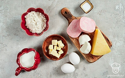 Куриные яйца вымойте, сварите вкрутую, остудите и почистите. Пармезан и моцареллу натрите на терке. Ветчину мелко покрошите. Приготовьте жаропрочную форму. Разогрейте духовку до 180 градусов.