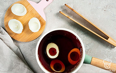 Начните приготовление. Для начала заварите крепкий черный чай и процедите его через сито в кастрюлю. Затем поместите в жидкость срезанные части вареных яиц. Поставьте кастрюлю на маленький огонь и прокипятите содержимое под крышкой в течение 15 минут.