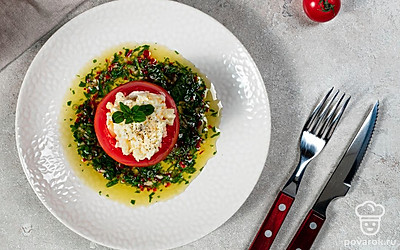 Красиво разложите фаршированные помидоры с яйцом и чесноком на тарелке, украсьте зеленью и подавайте к столу.