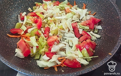 Затем тонко шинкуем капусту, нарезаем помидор и перец. Добавляем овощи в сковороду и тушим 10 минут. 