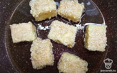 Сыр нарежьте средними кусочками. Обваляйте каждый кусочек в муке. Затем обваляйте в яйце. Затем в кунжуте. Снова в яйце и в кунжуте обваляйте. Налейте в сковороду масло, хорошо раскалите его и обжарьте кусочки сыра со всех сторон, до золотистой корочки.