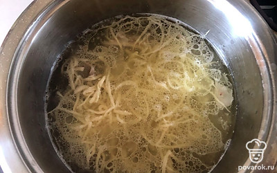 В бульон положите мелко нарубленный лук и чеснок. Лапшу положите в кастрюлю с бульоном и варите 2 минуты.