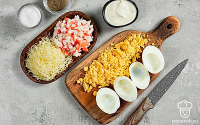 Сварите яйца. В небольшую кастрюлю налейте воду, посолите и положите яйца. Поставьте на огонь, доведите до кипения и варите еще 8-10 минут. Затем охладите, очистите яйца и разрежьте пополам. Желтки извлеките и измельчите вилкой или натрите на терке.