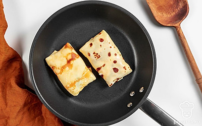 Пожарьте блины. В каждый блин заверните конвертиком часть начинки. Обжарьте фаршированные блины на разогретом растительном масле по 1 минуте с каждой стороны. Сначала жарьте со стороны шва.