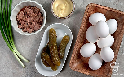 Заранее отварите яйца в подсоленной воде, остудите и очистите. Разрежьте на две равные половинки, извлеките желток. Вымойте зеленый лук, обсушите его с помощью бумажного полотенца. Откройте банку с печенью трески, слейте жидкость.