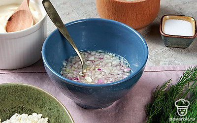 Подготовьте лук. Красный лук мелко нашинкуйте, залейте водой, уксусом, добавьте сахар. Перемешайте, маринуйте 10 минут, затем отожмите.