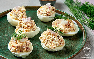 Сформируйте закуску. К измельченным продуктам добавьте маринованный лук и майонез, приправьте солью, хорошо перемешайте. В половинки яиц положите приблизительно по 1 ч. л. начинки.