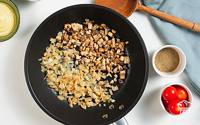 Пожарьте грибы. Сковороду поставьте на средний огонь, влейте растительное масло и выложите лук. Обжарьте до золотистого цвета и добавьте нарезанные шампиньоны. Продолжайте жарить до испарения лишней влаги и готовности грибов. Затем добавьте помидоры и немного потушите. Снимите с огня.