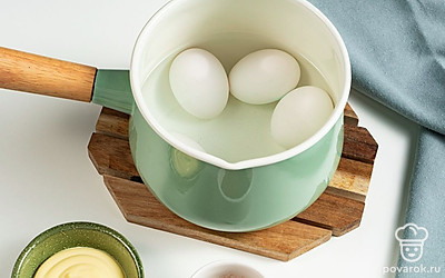 Сварите яйца. В подсоленной воде отварите до готовности куриные яйца. Снимите с огня, остудите, очистите от скорлупы и каждое яйцо разрежьте пополам. Извлеките желтки и натрите их на терке.