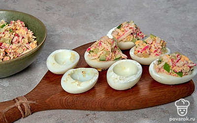 Приготовьте фаршированные яйца. В глубокой миске соедините нарезанные продукты, сдобрите майонезом, приправьте солью, хорошо перемешайте. В половинки яиц положите приблизительно по 1 ч. л. начинки, сформируйте аккуратную горку.