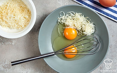 Займитесь начинкой. Немного тертого сыра на время отложите. 4 сырых яйца взбейте при помощи вилки или венчика, добавьте сырную стружку, яичные желтки. Интенсивно перемешайте.