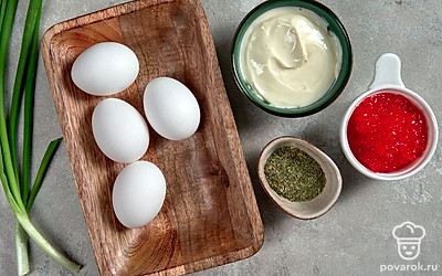 Сварите яйца вкрутую, остудите в холодной воде, почистите. Разрежьте пополам вдоль и извлеките желтки. Промойте и просушите лук, мелко нашинкуйте. Промойте и обсушите листья салата для подачи.