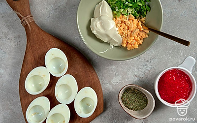 Приготовьте начинку. Хорошо разомните желтки в миске, добавьте к ним сливочный сыр и зеленый лук. Присыпьте специями на ваш выбор. Перемешайте.