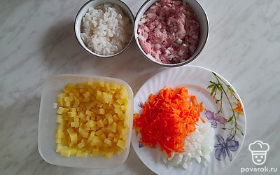 Отварите рис до готовности, картофель и лук нарежьте кубиком. Натрите морковь.