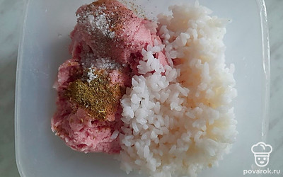 В отдельной миске соедините фарш, рис, специи и 1/2 репчатого лука.