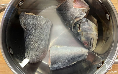 У рыбы удалить плавники, хвост и жабры, положить в кастрюлю и залить водой.