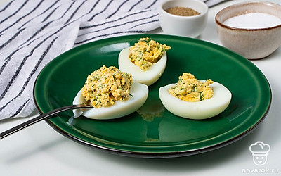 Нафаршируйте яйца. Возьмите чайную ложку и наполните белки начинкой. Сверху сделайте "шапочку".