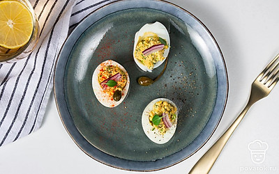 Выложите яйца, фаршированные зеленым луком, на красивое сервировочное блюдо и украсьте кружочками редиса и листочками петрушки. Они будут смотреться ярко и красиво.