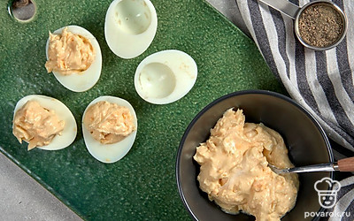 Нафаршируйте яйца. Приготовленной салатной смесью наполните каждую половинку белка, сверху сформируйте аккуратную горку.