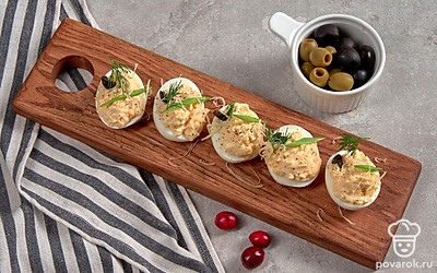 Яйца, фаршированные плавленым сыром, оформите измельченной зеленью.