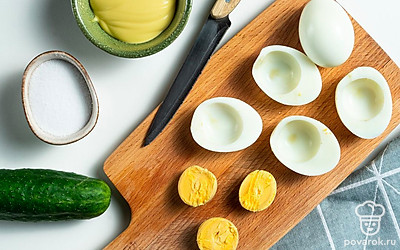 Подготовьте яичные "лодочки". Залейте пять яиц холодной водой. Поставьте на огонь. Дайте закипеть. Если вода сильно бурлит, огонь убавьте. Варите 10 минут до крутого состояния, чтобы желток и белок стали твердыми. Остудите, положив в холодную воду. Почистите от скорлупы. Смочите нож в воде, разрежьте яйца вдоль точно посередине. Выньте желток.