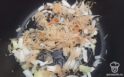 Лук нарежьте кубиками и обжарьте на подсолнечном масле вместе с квашеной капустой 5 минут.