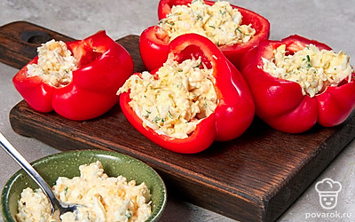 Нафаршируйте перцы. Половинки перцев полностью заполните начинкой, разровняйте и утрамбуйте ее. Разрежьте перцы пополам, а затем порежьте еще надвое. Закуска получается в форме продолговатых полумесяцев.