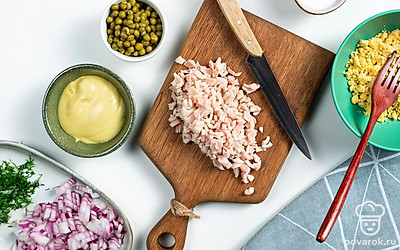 Займитесь начинкой. Яйца сварите вкрутую — 8-10 минут после закипания. Остудите в холодной воде. Почистите так, чтобы не повредить белок. Затем разрежьте яйца вдоль на две части. Извлеките желток. Измельчите его в крупную крошку. Кальмары спустите в кипящую воду, варите 3-4 минуты. Остудите под струей холодной воды. Нарежьте мелкими кубиками.