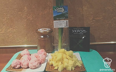 Очистите картофель, нарежьте на средние кусочки. Посолите фарш. Натрите чеснок на крупной терке. Нарежьте зеленый лук. Слепите небольшие фрикадельки. Поставьте греться около литра воды, доведите до кипения.