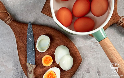 Яйца отварите вкрутую. Вскипятите воду, выложите куриные яйца и варите 8-10 мину с момента закипания. Затем достаньте яйца из кастрюли, поместите в емкость с холодной водой и остудите. Очистите от скорлупы и разрежьте пополам. Отделите желтки от белков.