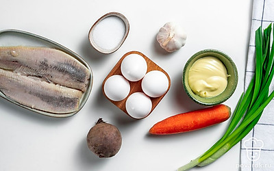 Заранее отварите свеклу, морковь и яйца в подсоленной воде. Остудите и очистите. Вымойте зеленый лук, обсушите зелень с помощью бумажного полотенца. Чеснок очистите.