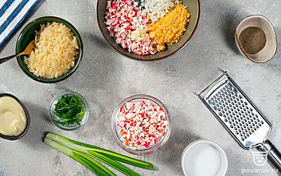 Приготовьте начинку. Натрите сыр и крабовые палочки на терке с мелкими ячейками. Желтки разомните вилкой. Зелень измельчите. Чеснок выдавите через пресс. Соедините вместе эти продукты, добавьте майонез. Посолите и поперчите по вкусу.