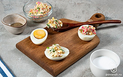 Нафаршируйте яйца. Возьмите маленькую ложку и начините белки. Наверху сделайте красивую "шапочку".