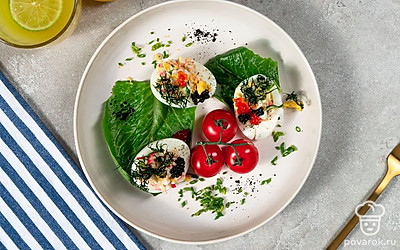 Фаршированные яйца будут красиво смотреться, если вы украсите их веточками укропа и колечками оливок.