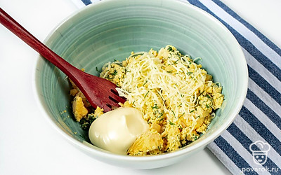 Приготовьте начинку. Зубчики чеснока разрежьте пополам и удалите сердцевину. Оставшиеся половинки чеснока измельчите. Сыр пропустите через терку, а укроп измельчите. Вареные яйца разрежьте на две части, желтки извлеките, переложите их в отдельную емкость и разомните. Туда же добавьте чеснок, сыр, укроп и специи по вкусу. Сдобрите начинку майонезом и тщательно перемешайте.