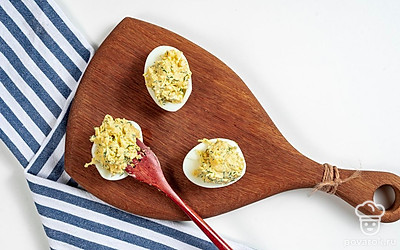 Приготовьте блюдо. Яичные белки слегка промойте холодной водой, просушите. Нафаршируйте яйца готовой сырной начинкой, формируя аккуратную горку.