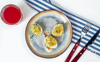 Чтобы готовая закуска смотрелась еще красивее и аппетитнее, посыпьте ее небольшим количеством сушеных трав. Выложите блюдо на тарелку или дощечку для подачи. При желании в фаршированные яйца можно поместить шпажки.