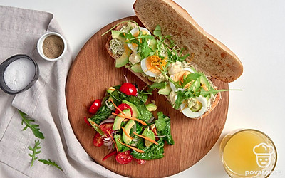 При подаче украсьте чиабатту с авокадо листьями руколы.