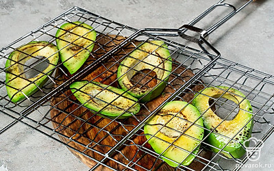 Пожарьте авокадо на гриле. Выложите авокадо на решетку гриля и готовьте на среднем огне по две минуты с каждой стороны. Готовые дольки посолите и поперчите по вкусу.