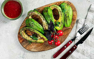 Готовые кусочки авокадо выложите на красивую тарелку и дополните листочками базилика.