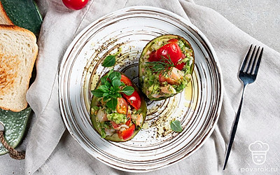 При подаче украсьте фаршированные авокадо маслинами.