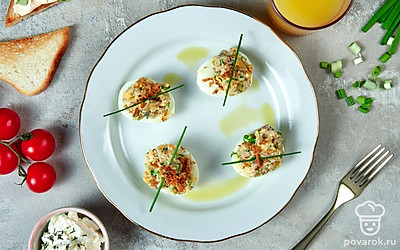 Яйца, фаршированные сыром и грибами, разложите на тарелке, украсьте листьями свежей петрушки или укропа.