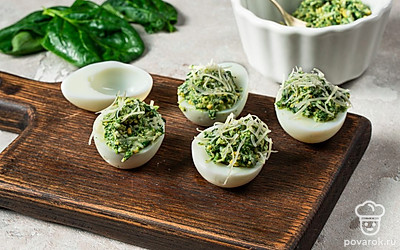 Сделайте фаршированные яйца. В глубокую емкость положите шпинат, желтки, сыр. Добавьте соль, перец, паприку. Тщательно перемешайте. В белки яиц положите начинку.