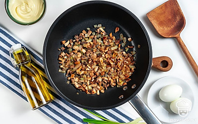 Начните приготовление. Грибы нарежьте небольшими по размеру кубиками, а репчатый лук и зелень измельчите. На сковороду налейте растительное масло, выложите на нее грибы, поместите на средний огонь. Помешивайте в течение нескольких минут. Затем добавьте к грибам репчатый лук, посолите по вкусу. Обжаривайте начинку, не переставая помешивать. В конце добавьте в сковороду зеленый лук и доведите содержимое до готовности.