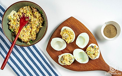 Приготовьте закуску. Яичные белки аккуратно промойте, чтобы они стали чистыми. После этого заполните их готовой сырно-грибной начинкой. Готовое блюдо отправьте в холодильник на 10-15 минут.