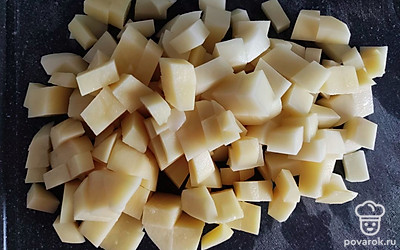 Картошку почистить и нарезать кубиком. Поместить в бульон.